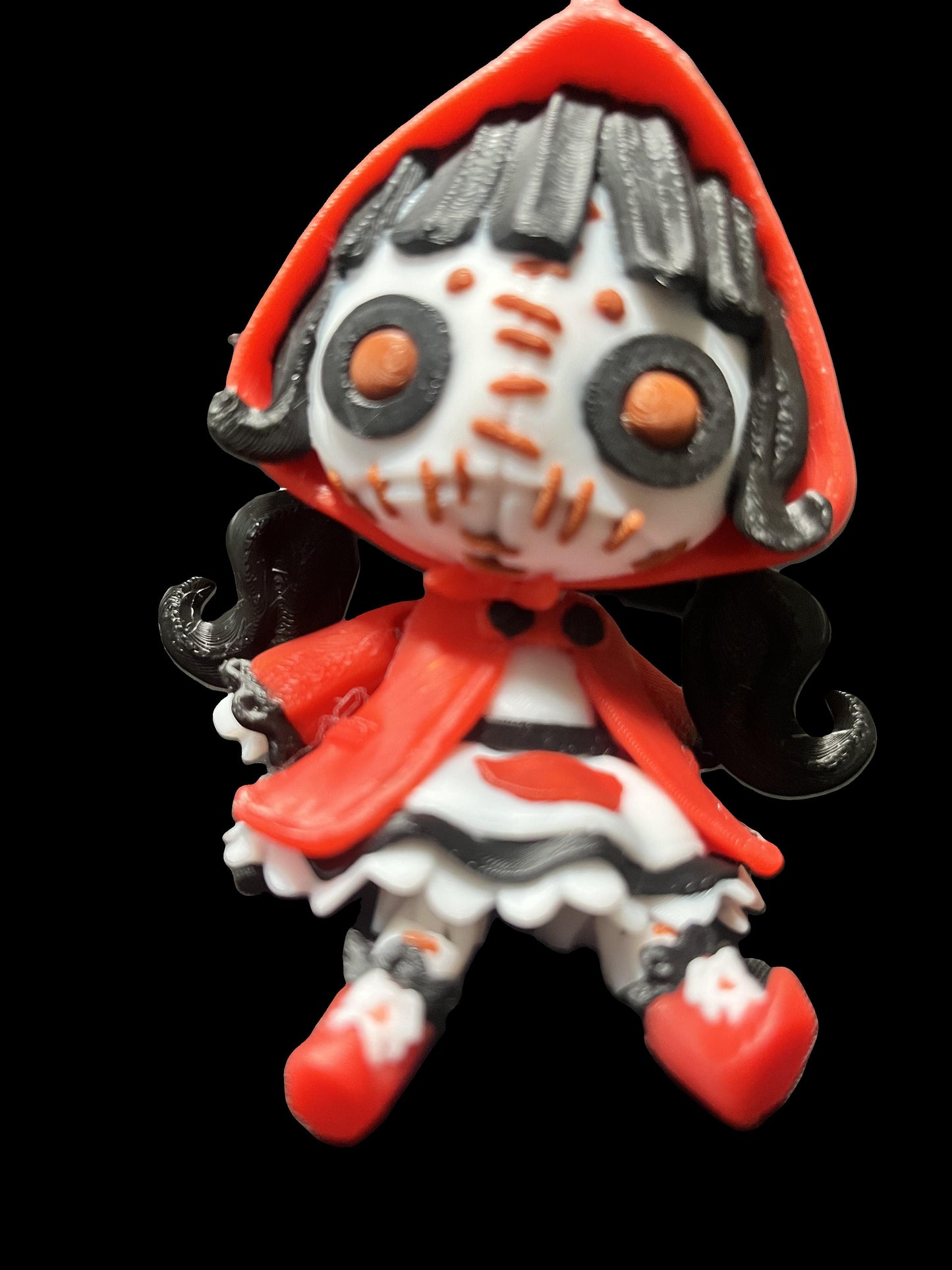 Creepy doll wearing a crimson cloak